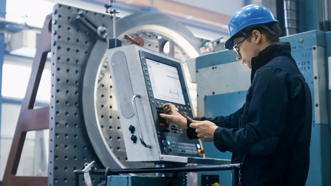 Un employé d'une usine regarde les données de la machine en se concentrant sur le suivi de l'efficacité de la production OEE