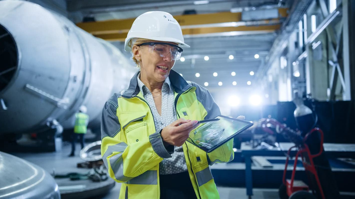 Person with a headset in helmet working on a computer inside a hall
