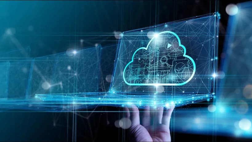 Grafika przedstawiająca dłoń trzymającą laptop z hologramem chmury, w której widoczne są ikony technologii. Tło obrazuje sieć połączeń, co odnosi się do zdalnego zarządzania i integracji danych w Jira Cloud.