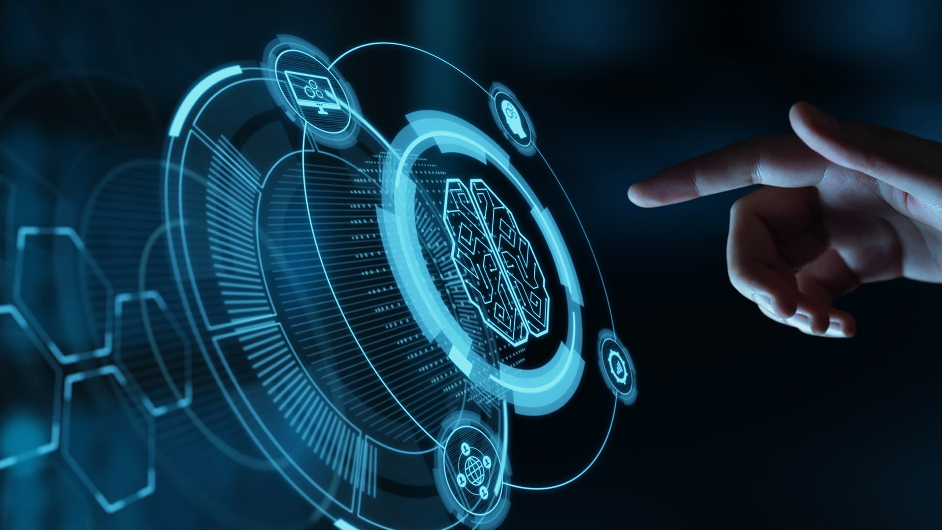 Zdjęcie przedstawia prawą dłoń wysuwającą się z prawego boku zdjęcia, wokół niej widoczne jest ciemne tło, sama dłoń jest lekko podświetlona przez światło ekranu do którego się kieruje. Ekran nie jest płaskim obrazem, a ikonami wyświetlonymi w przestrzeni, jakby wysuwając się w stronę użytkownika. Po środku widoczna jest duża ikona przedstawiająca mózg, wokół niej rozmieszczonych jest kilka mniejszych ikon. Z kontekstu wynika, że zdjęcie przedstawia nowoczesne technologie, sposób przedstawienia ekranu sugeruje korzystanie z Rozszerzonej Rzeczywistości a ikona mózgu może symbolizować Sztuczną Inteligencję (AI). Zdjęcie jest grafiką okładkową do success story firmy Transition Technologies PSC i pojawia się jako ilustracja wpisu o tytule: Unowocześnienie szkoleń i obsługi klientów z wykorzystaniem Assisted Reality i Mixed Reality.