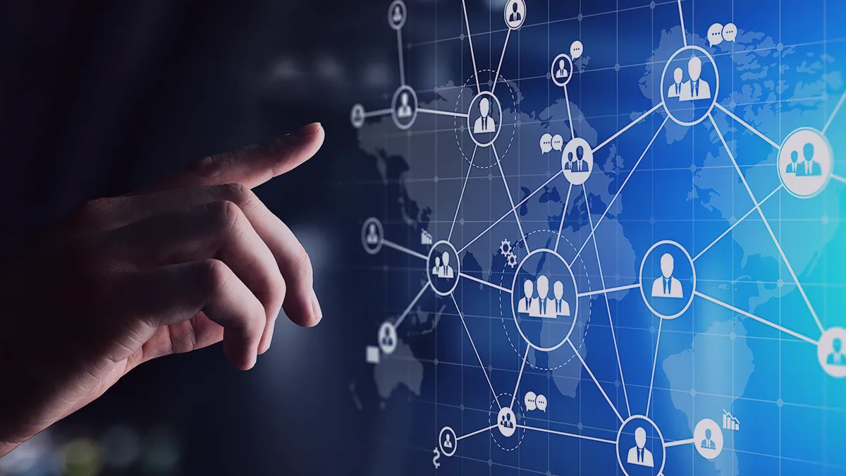 The photo depicts a hand extended in front of a screen showing user icons connected to each other by lines - a symbolic map of user connections. The photo is the cover graphic for a Transition Technologies PSC success story titled: Outsourcing IT services for OneSpan R&D scaling.