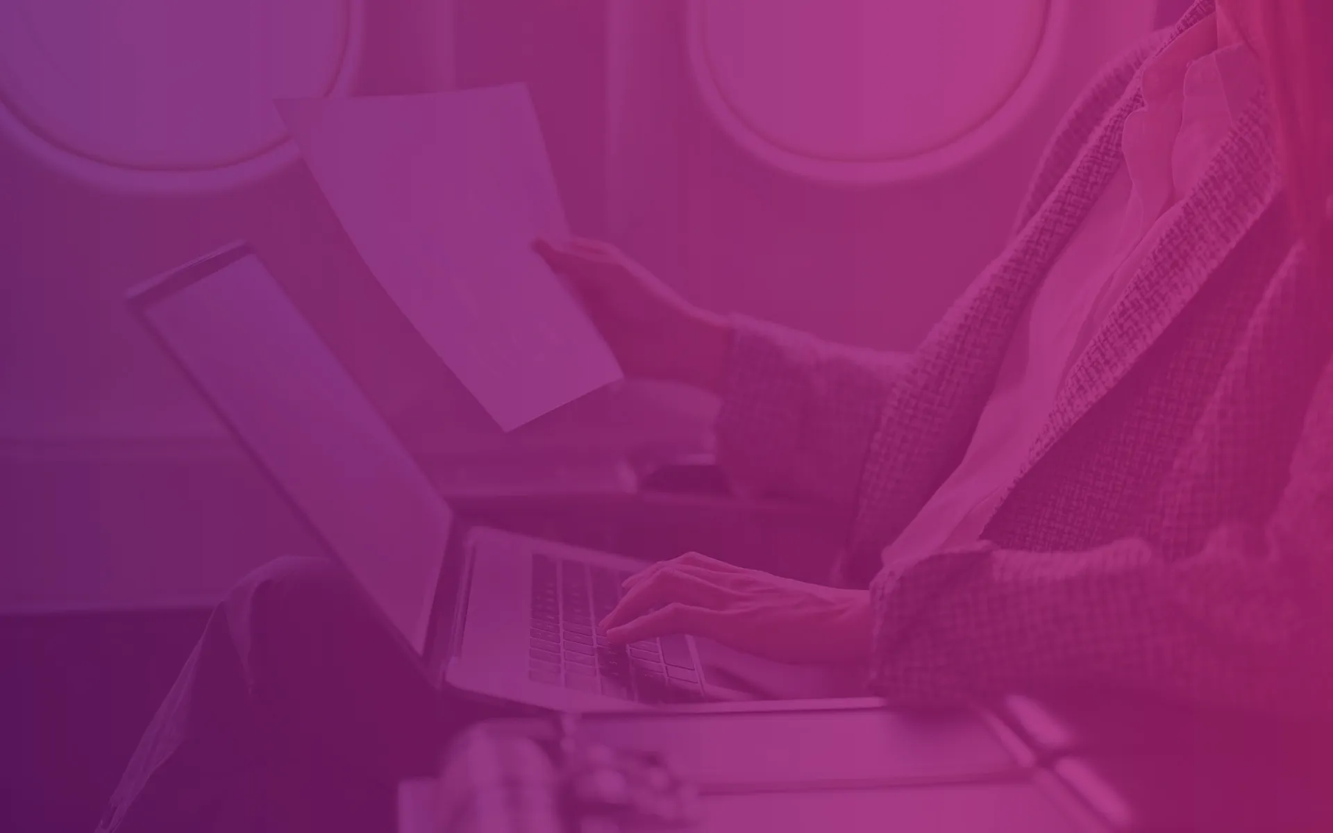 Featured graphic for a page with all Transition Technologies PSC blogposts, , a purple and pink gradient applied to a photo showing the hands of a woman sitting at a laptop on an airplane