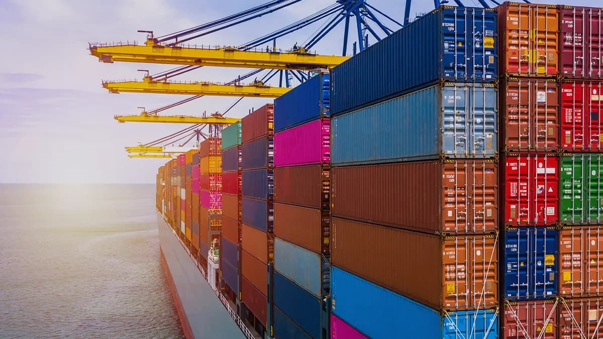 Photo showing a cargo ship loaded with containers. The photo is a cover graphic for a success story of Transition Technologies PSC company titled: R&D outsourcing – Greenfield implementation for the ocean transportation company