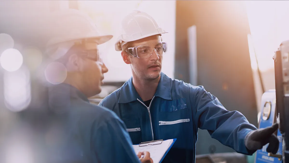 A banner where in the foreground is an individual wearing a hard hat and safety glasses on a production line. The text overlay reads: The image represents a case study or promotional material highlighting the successful implementation of a Knowledge Management System for Philip Morris International.