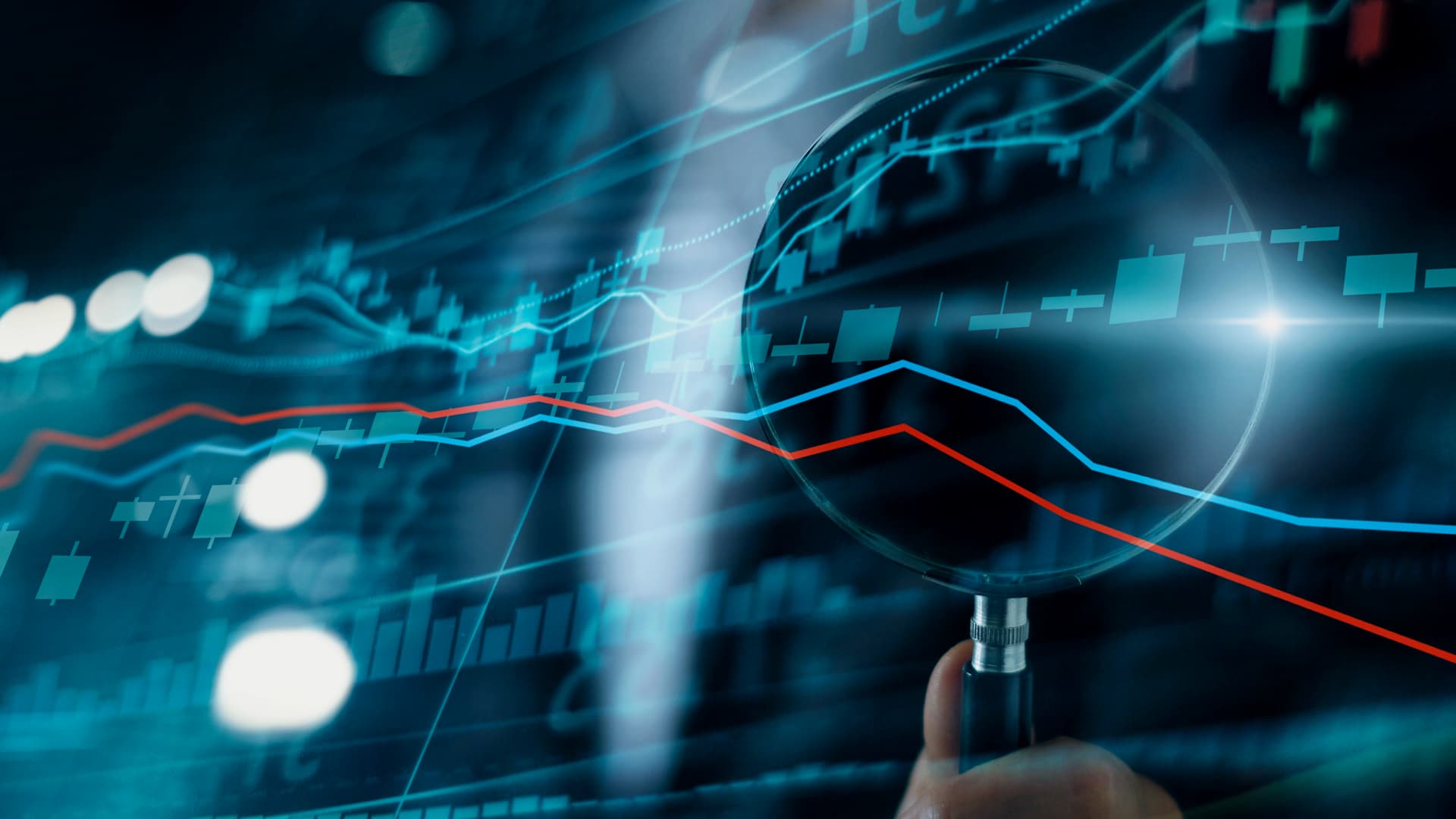 Zdjęcie przedstawiające ekran, na którym widoczne są wykresy oraz dłoń z dużą lupą skierowaną na fragment wykresu. Zdjęcie jest grafiką okładkową do artykułu blogowego firmy Transition Technologies PSC pod tytułem: Płynne Zarządzanie Incydentami - CMDB kluczowym narzędziem w tworzeniu sprawnego i odpornego środowiska IT