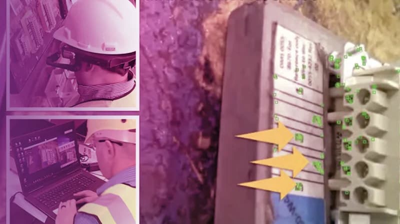 Two people collaborate at a laptop, with one pointing at the screen using a pencil.