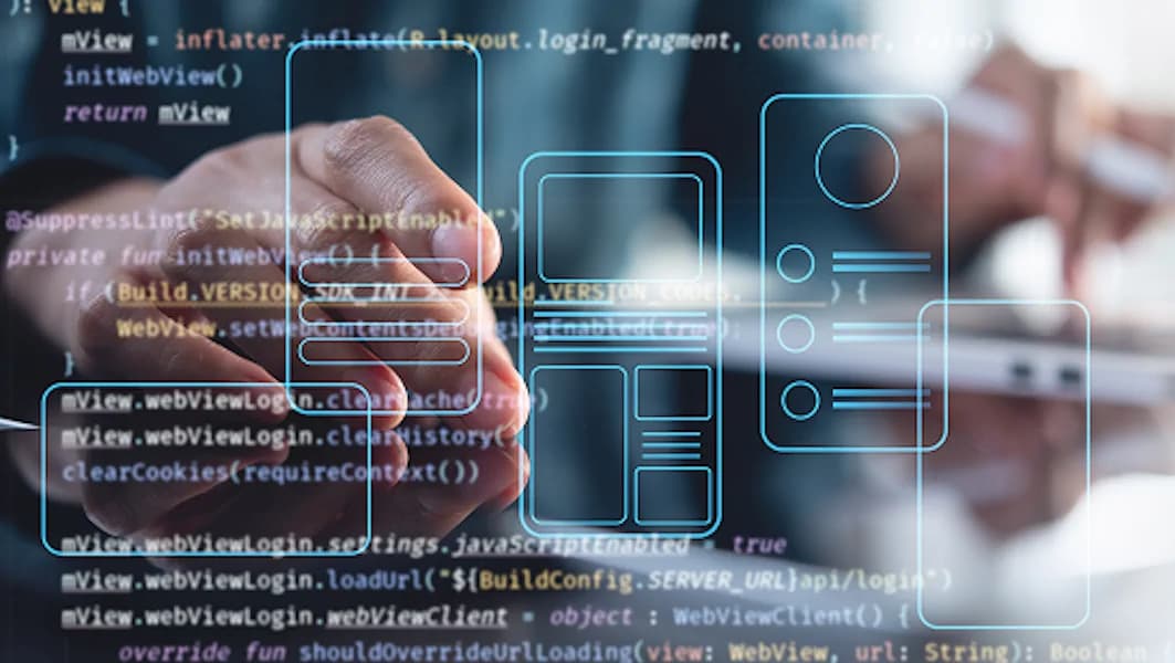 Person using a tablet with source code and wireframes in the background — representing mobile app development and UI design