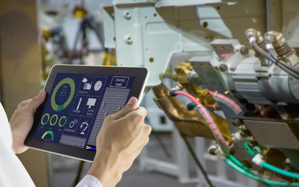 Engineer controlling industrial machine using a tablet with control panel interface