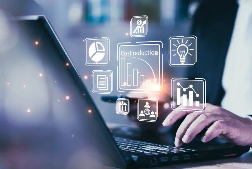Businessman using laptop with digital icons of analytics and cost reduction